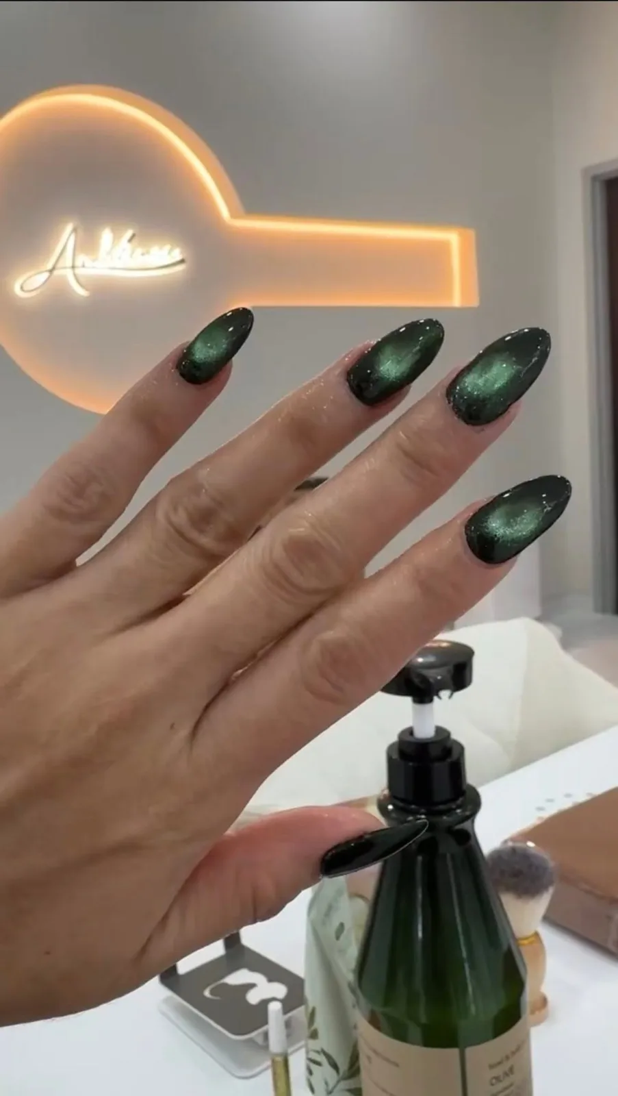 Dark green cat-eye gel on almond nails