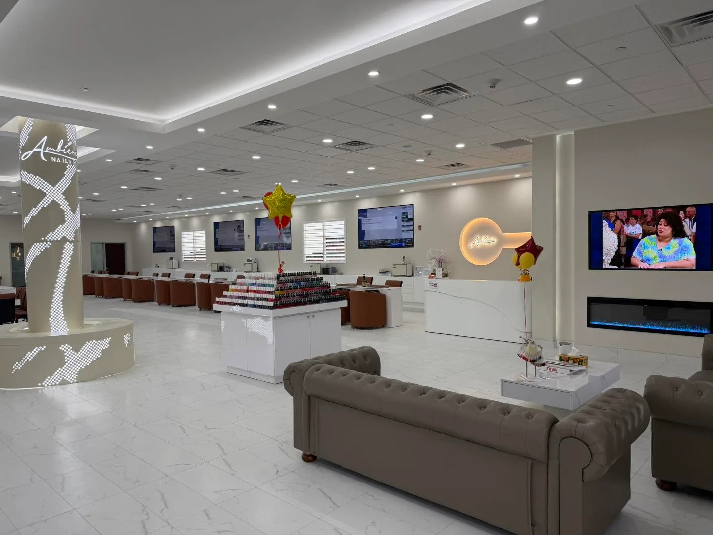 The waiting area: a tufted sofa, a fireplace under the TV, and the front desk